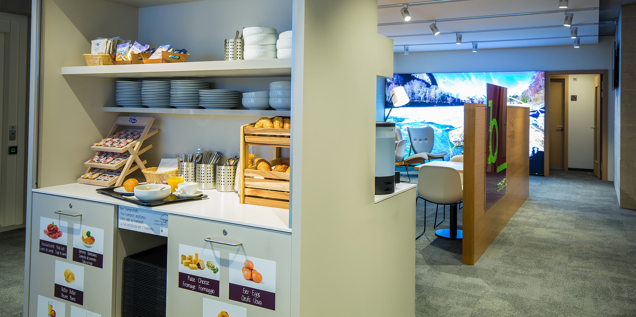 Breakfast area in the B_smart Motel Landquart with pastries, dishes, and drinks on a shelf