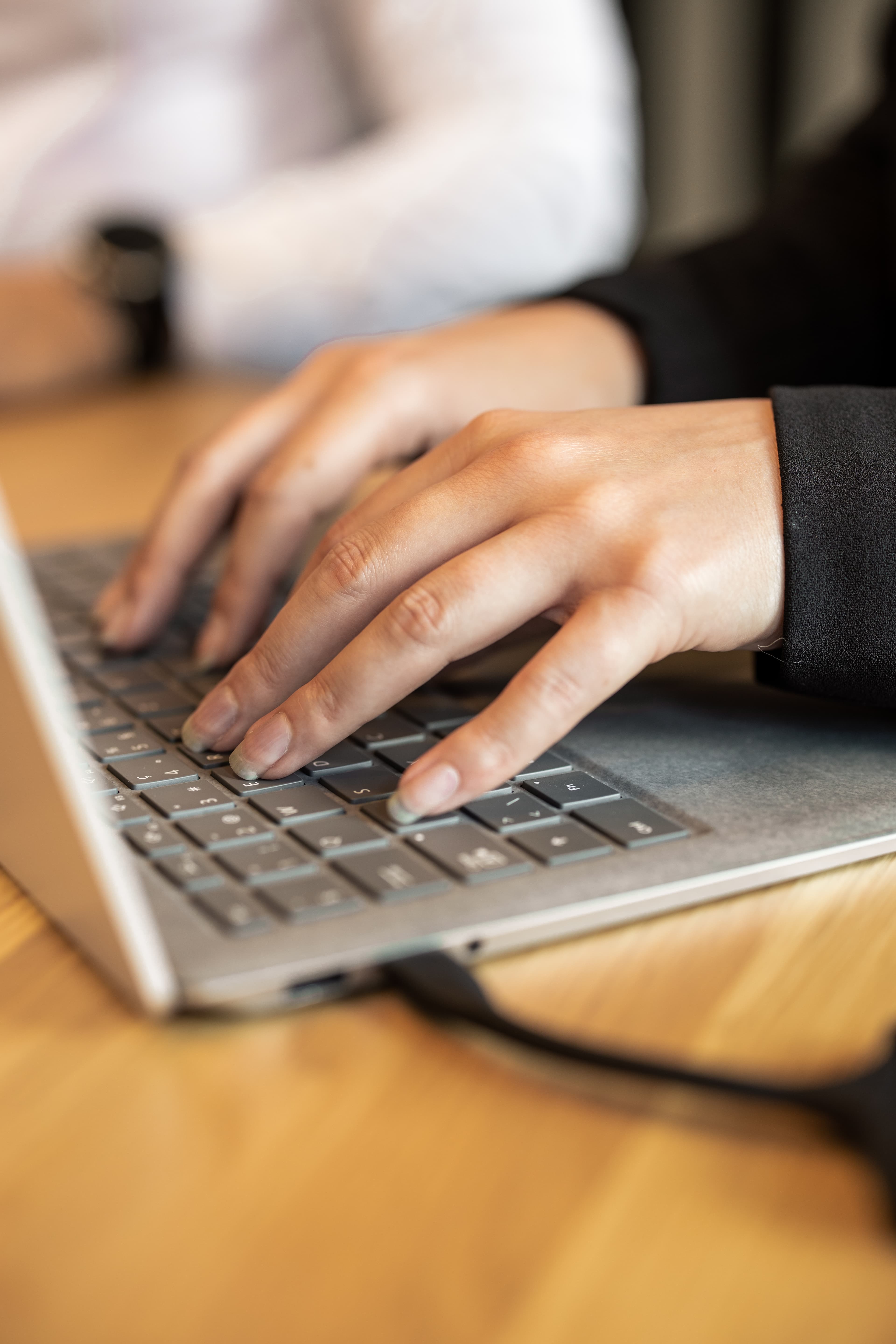 Person typing on a laptop in a meeting room at the B Smart Hotel Widnau